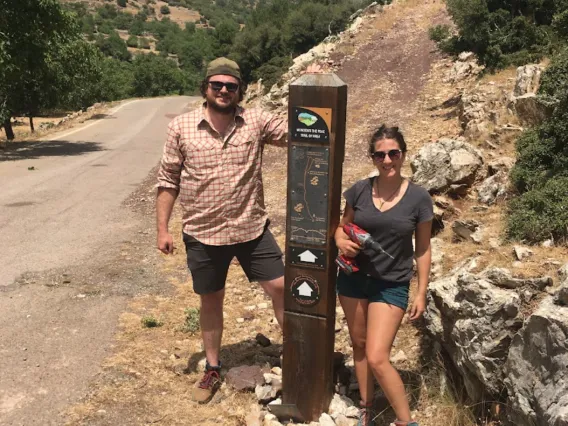 man and woman standing by a trail marker at Mt. Lykaion