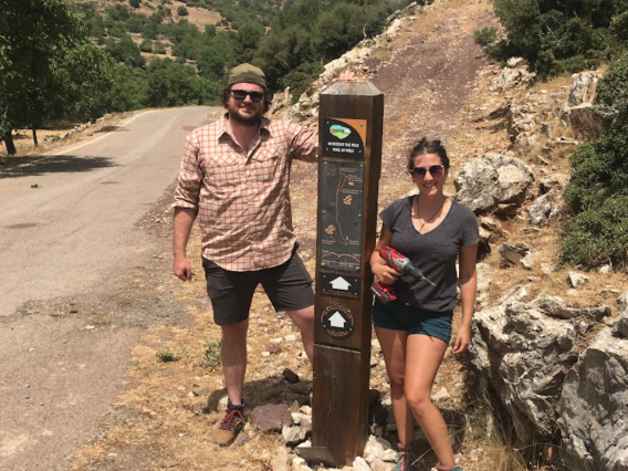 man and woman standing by a trail marker at Mt. Lykaion