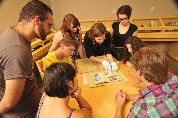 Students and a professor examining text.