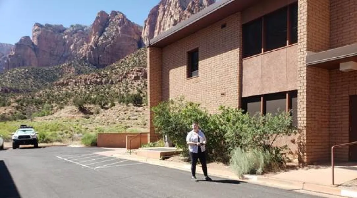 Maddie Moeller in front of a building at Zion National Park