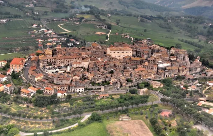 landscape of a cluster of buildings surrounded by green fields