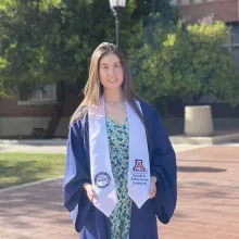 Johnna Oliver in outdoors in academic regalia