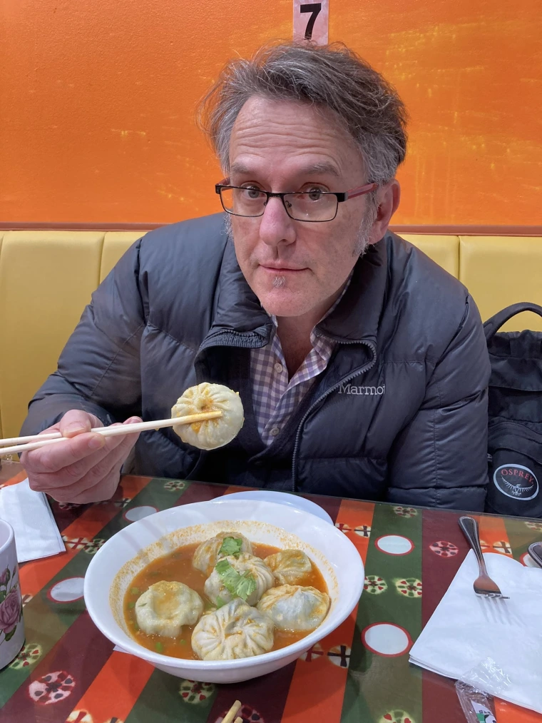 Victor Braitberg eating a dumpling with chopsticks