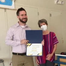 Nick Smith, holding staff award, with Diane Austin